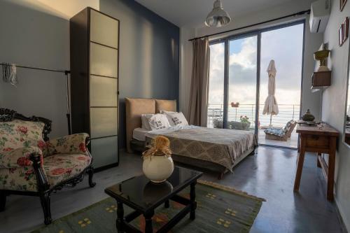 a bedroom with a bed and a chair and a window at Serenity Boutique Suites in Athani