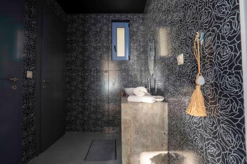 a bathroom with a shower with a sink and a mirror at Serenity Boutique Suites in Athani