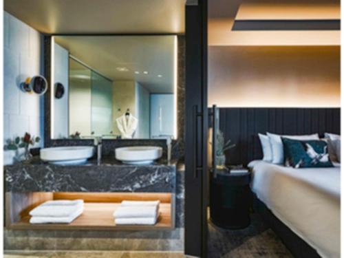 una camera da letto con due lavandini e un grande specchio di Pullman Melbourne On the Park a Melbourne