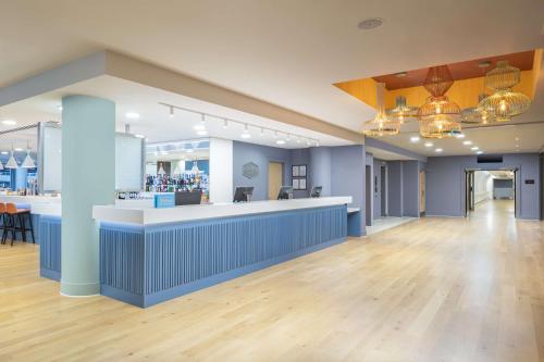 a lobby of a store with a counter and chairs at Hampton by Hilton London Gatwick Airport in Horley