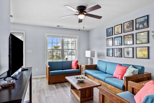 a living room with a blue couch and a tv at Anchors Away Unit 4 Duplex in Atlantic Beach